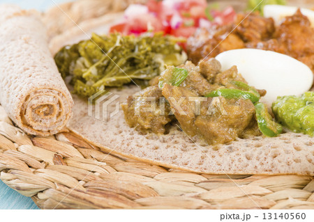 Ethiopian Feast - Injera with doro wat, yebeg alicha, misir wat, kik alicha, and gomen  13140560