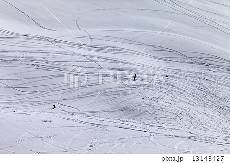 Silhouettes of snowboarders and skiers on off piste slope 13143427
