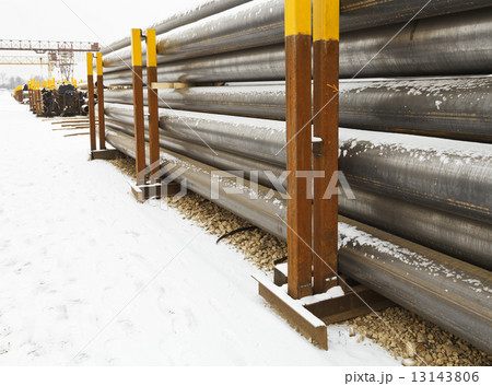stacks of construction pipes on outdoor warehouse 13143806
