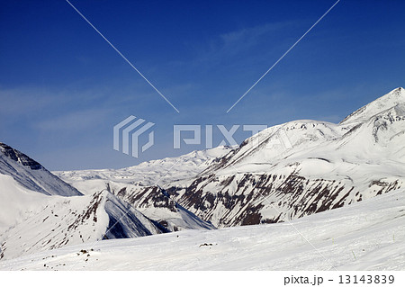 Ski slope and snowy mountains in sun day Ski slope and snowy mountains in sun day 13143839
