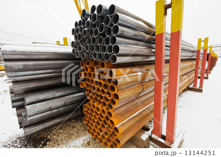 pile of construction pipes in outdoor warehouse 13144251