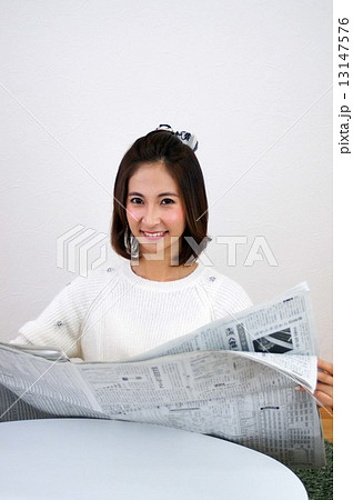 新聞を読む若い女性 13147576