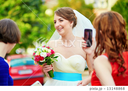 Bridesmaid is taking photo of a bride Bridesmaid is taking photo of a bride 13148868