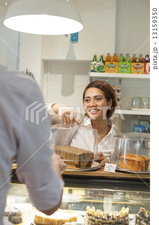 An Asian waitress happily serving a customer. An Asian waitress happily serving a customer. 13159350