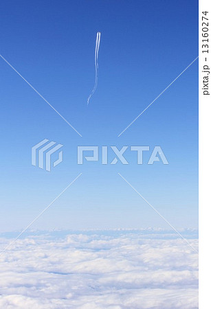 はるか雲海の上を飛行機雲を引きながら流れるように静かに進む飛行機 13160274