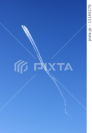 はるか上空を飛行機雲を引きながら流れるように静かに進む飛行機 13160276