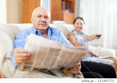 mature couple together with newspaper 13164773