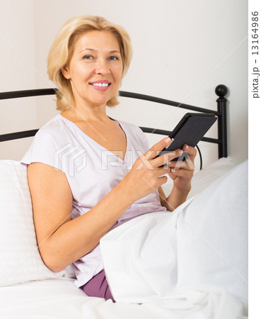 blonde mature woman with tablet 13164986