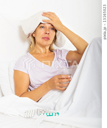 pensioner laying in bed with towel on forehead pensioner laying in bed with towel on forehead 13165023