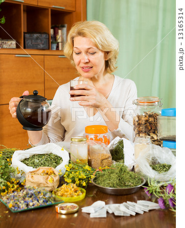 Mature woman brewing herbs Mature woman brewing herbs 13165314