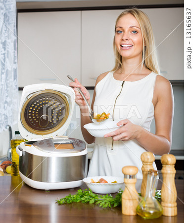 Woman cooking with multicooker 13165637