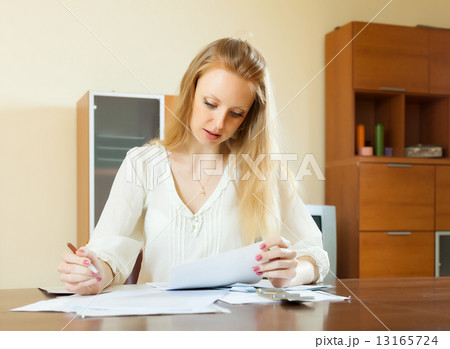 serious long-haired woman fills in questionnaire 13165724