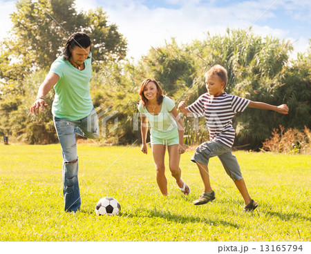 Family of three with teenager playing in soccer 13165794