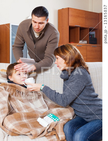 Parents giving tablets to son 13165837