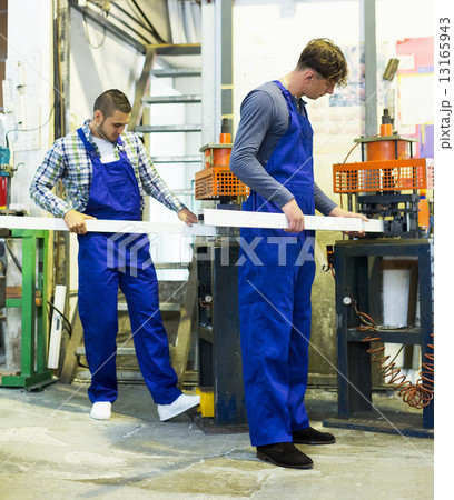 Two workers working on a machine Two workers working on a machine 13165943