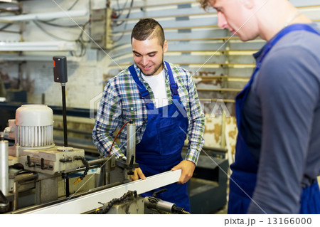 Two workers working on a machine Two workers working on a machine 13166000
