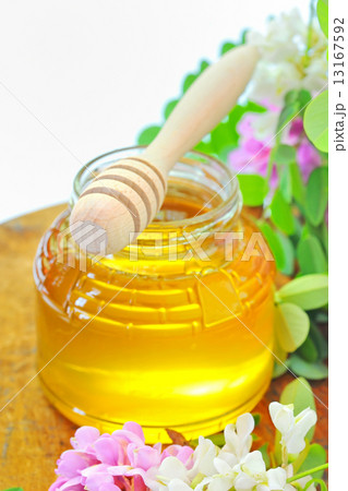 glass jar full of honey and stick with acacia pink and white fl glass jar full of honey and stick with acacia pink and white fl 13167592