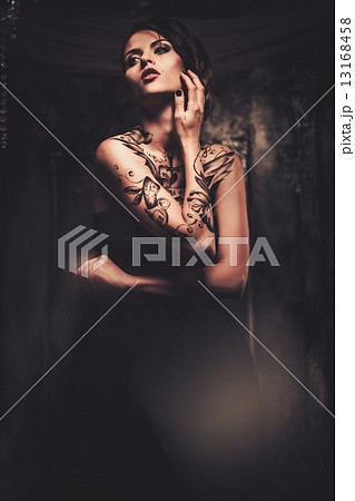 Tattooed beautiful woman in old spooky interior 13168458