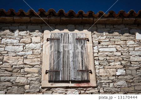 Old window with closed shutters 13170444