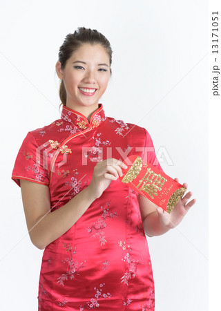 1 young chinese woman in cheongsam opening her lunar new year red packet isolated white background 13171051