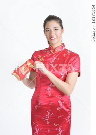 1 young chinese woman in cheongsam opening her lunar new year red packet isolated white background 13171054