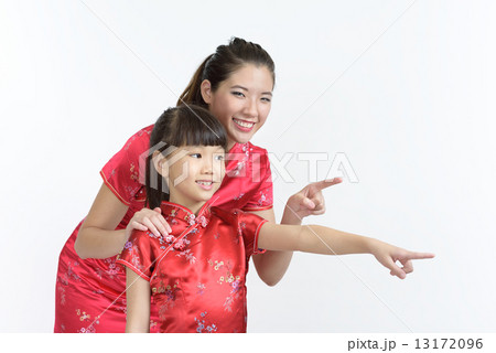 Young chinese mother and daughter looking pointing at lunar new year gifts isolated white background Young chinese mother and daughter looking pointing at lunar new year gifts isolated white background 13172096