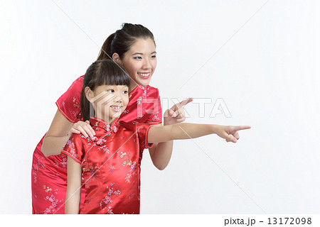 Young chinese mother and daughter looking pointing at lunar new year gifts isolated white background 13172098