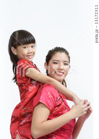 Young Chinese mother in cheongsam piggyback daughter isolated white background 13172311