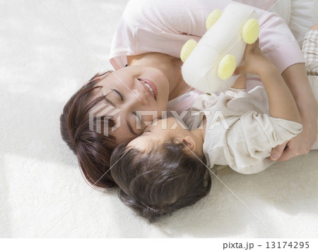 寄り添って寝転ぶ親子 13174295