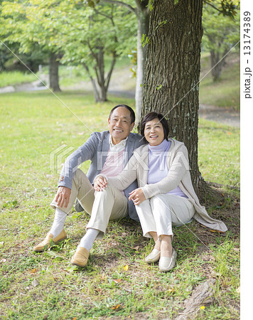 木にもたれて座る中高年夫婦 木にもたれて座る中高年夫婦 13174389