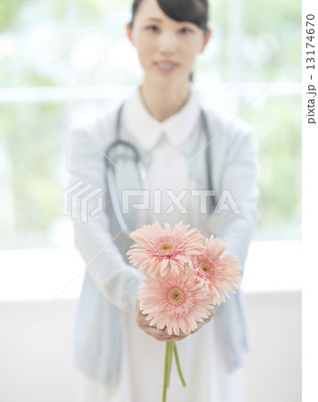 ガーベラの花を持つ看護士 13174670