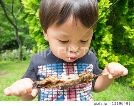 男の子がニジマスを食べている 13196491