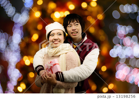 イルミネーションが綺麗なところでハグしてる恋人たち 13198256