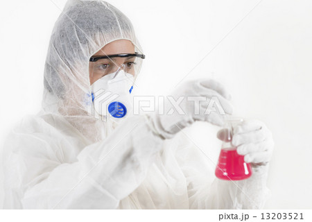 Young Woman wearing protective suit holding some laboratory glassware 13203521