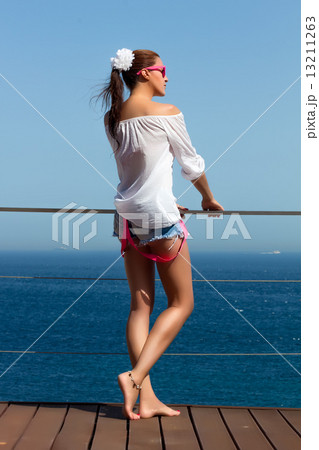 Backside of Fashionable Girl in Denim Shorts. Beauty Legs 13211263
