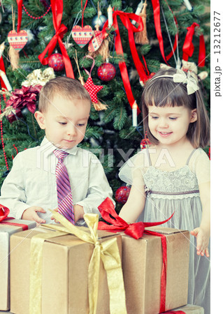 Small children and boxes with gifts near a Christmas fir-tree 13212677