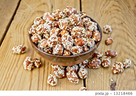 Peanuts in caramel with sesame on wooden board Peanuts in caramel with sesame on wooden board 13218466