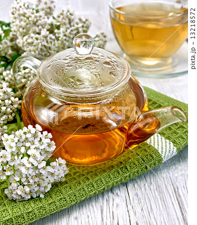 Tea with yarrow in glass teapot on board Tea with yarrow in glass teapot on board 13218572