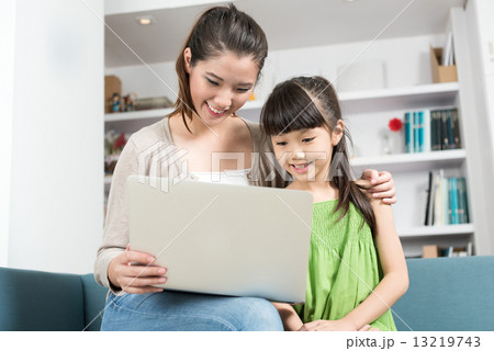 Young chinese mother and daughter using mobile device laptop at home Young chinese mother and daughter using mobile device laptop at home 13219743