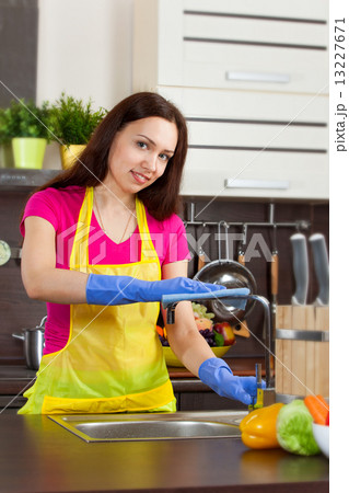 Young woman cleaning kitchen Young woman cleaning kitchen 13227671