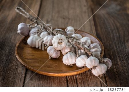 Bunch of dried garlic bulbs on a wooden table Bunch of dried garlic bulbs on a wooden table 13237784
