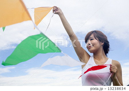 A woman in a Kyoto park holding up a colourful row of flags. A woman in a Kyoto park holding up a colourful row of flags. 13238634