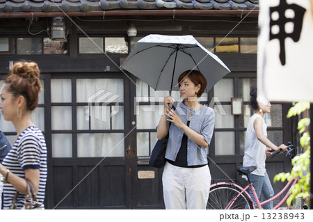 Woman standing outdoors, holding an umbrella. Woman standing outdoors, holding an umbrella. 13238943