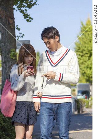 カップル　ポートレート  スマホを見ながら会話 13240212