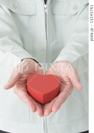 まごころ込めてハートを差し出す作業員男性手元 13245761