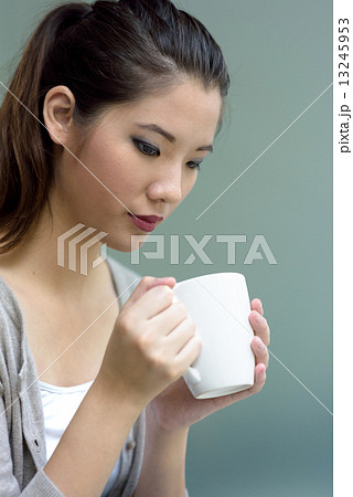 One young chinese woman holding a cup of hot coffee 13245953