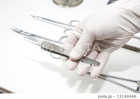 metallic surgical instrument in the surgeon's hand 13248466