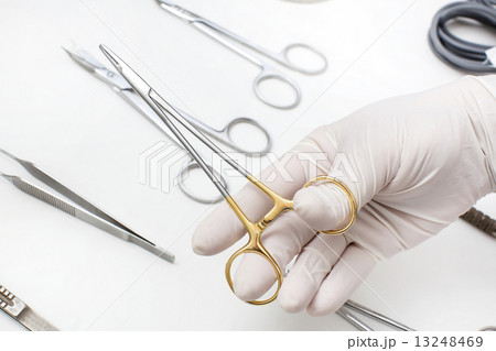metallic surgical instrument in the surgeon's hand 13248469