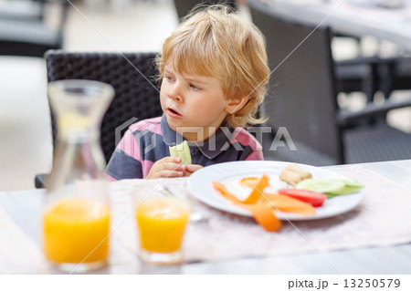 Little kid boy having healthy breakfast in hotel restaurant or c Little kid boy having healthy breakfast in hotel restaurant or c 13250579