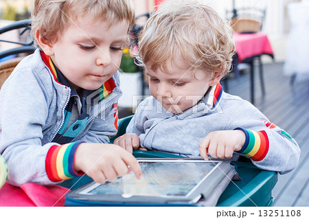 Two little sibling boys having fun together with tablet pc. 13251108